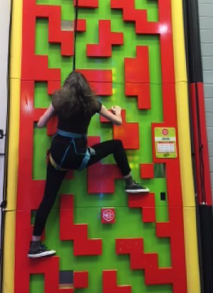 Anna climbing a wall at a climbing centre