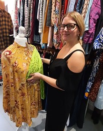 Photo of Lotte Finch surrpinded by clothes in a Brandon charity shop